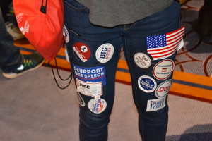 Photo by David Fishman: A student's legs covered in stickers handed out at CPAC